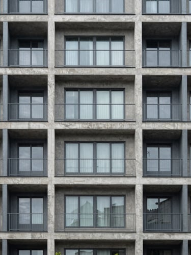 Straight-on structural detail of a modern steel and concrete apartment building facade, neutral daylight, architectural precision.