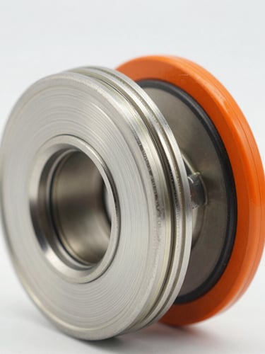 Macro close-up of a triple-offset butterfly valve disc and laminated metal seal, pristine steel and safety orange accents, sharp technical focus
