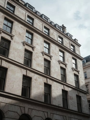 Low-angle architectural photograph of a Portland stone facade in Mayfair, sharp overcast London daylight, deep shadows, corporate editorial style.