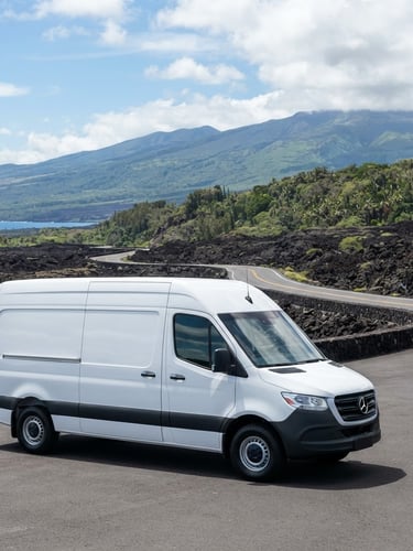 Immaculate white delivery vehicle parked against a dramatic Hawaiian volcanic landscape, sharp focus, bright high-key daylight