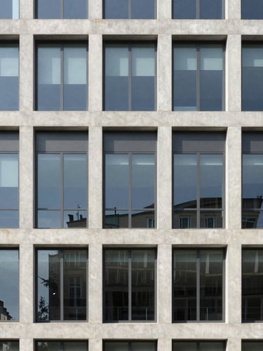 A sharp straight-on architectural shot of a modern concrete and glass office building facade under bright natural daylight, neutral muted tones