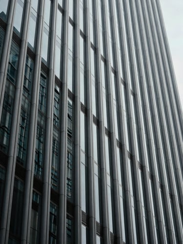 Abstract geometric lines of a modern corporate skyscraper facade, sharp architectural shadows, cool diffused daylight, high-end editorial framing.