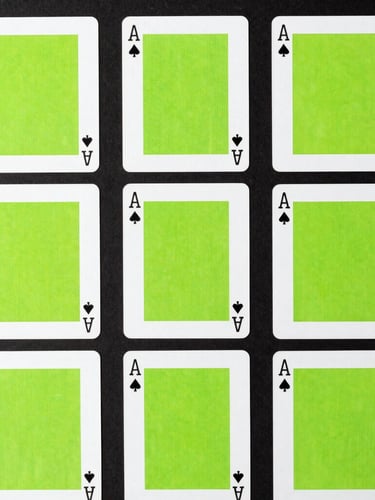 Crisp top-down flat-lay of minimalist playing cards with bold typography and neon green accents arranged in a perfect geometric grid on a dark surface, sharp studio shadows.