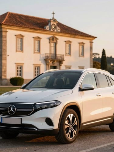 A pristine Mercedes Benz EQA250 parked in front of a historic Portuguese estate under warm golden hour light, showcasing modern luxury.