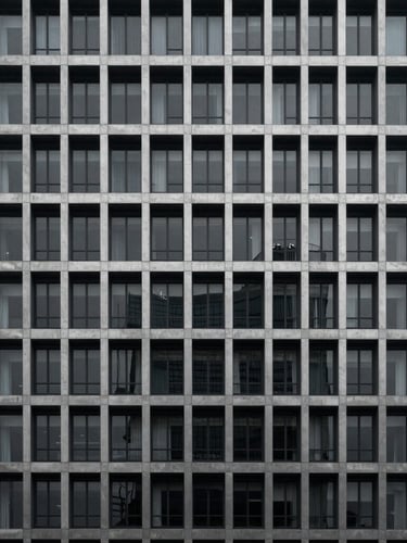 Minimalist architectural photography of a modern concrete and steel high-rise facade, cool overcast daylight, deep charcoal and silver tones, sharp focus, 35mm