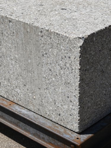 Extreme close-up of a raw granite block resting on a structural steel plate, harsh direct sunlight, high-contrast textures