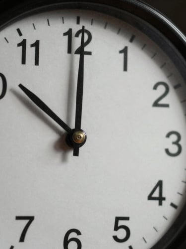 Stark close-up of a vintage analog ticking clock with deep shadows, high-contrast natural light, muted tones, 35mm lens
