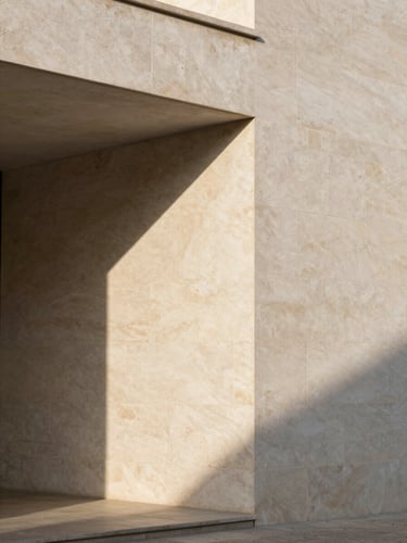 Minimalist Portuguese architecture, clean limestone facade with sharp geometric afternoon shadows, soft warm-toned stone texture, editorial framing.