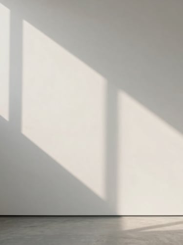 A clean, straight-on architectural view of soft morning light casting long, geometric shadows on a smooth, off-white gallery wall, minimalist, peaceful, organized, no people.