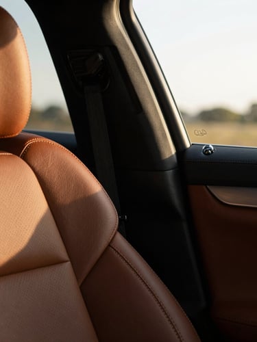 A quiet close-up of a luxury car's leather interior, warm morning light streaming through the window, shallow depth of field, 35mm.