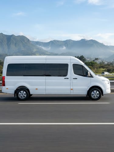Side profile of a spotless modern executive white passenger van driving on a clean highway near Bogotá, bright morning daylight, professional editorial corporate photography style.