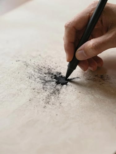 Close-up of hands smudging charcoal on heavily textured parchment paper, soft directional side-lighting, 35mm