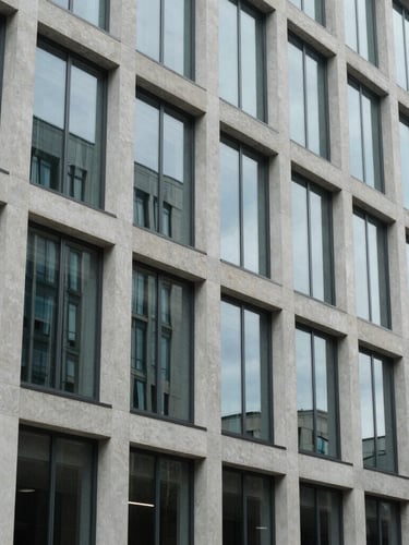 Architectural close-up of a modern glass and concrete international court building, clean lines, cool daylight reflecting off the facade.