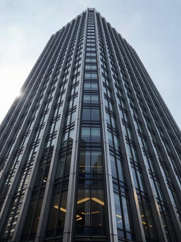Wide-angle environmental photograph of a modern steel and glass skyscraper under bright, high-contrast natural daylight, crisp architectural shadows, full-frame composition.