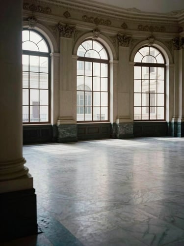 Wide environmental shot of an empty colonial-era banking hall in Buenos Aires, tall arched windows casting cool diffuse daylight across marble floors, no people, architectural detail of ornate plasterwork columns in the left foreground