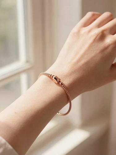 Close-up of a delicate rose gold bracelet on a woman's wrist, soft warm window light casting elegant shadows, shallow depth of field