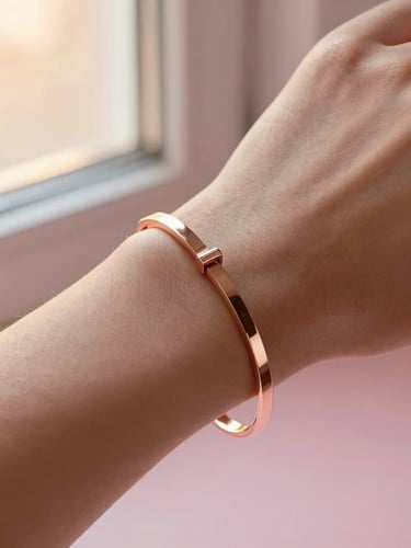 Macro detail shot of a gleaming rose gold bracelet on a woman's wrist, warm golden-hour window light, soft pink tones, shallow depth of field