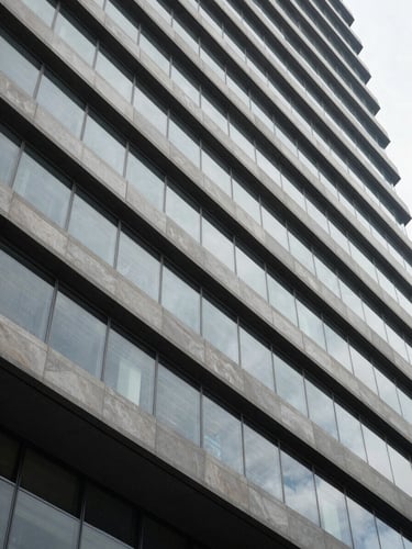 Abstract architectural lines of a modern corporate building, sharp angles, cool natural daylight, objective architectural photography.