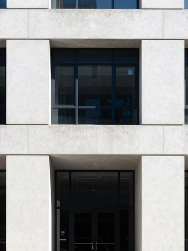 Sober architectural photography of a modern law office facade, clean concrete lines, cool natural daylight, sharp focus, 35mm lens