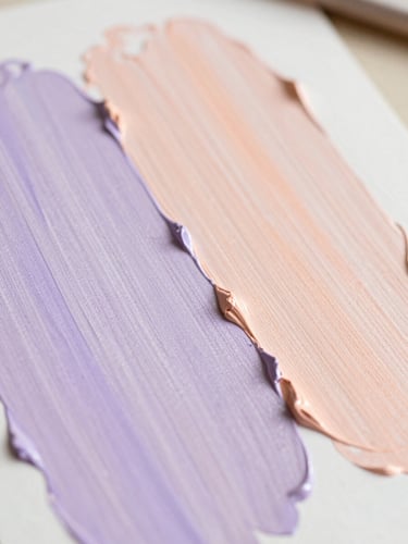 A close-up of paint texture on canvas, soft pastel colors of lavender and peach, bright natural daylight, shallow depth of field