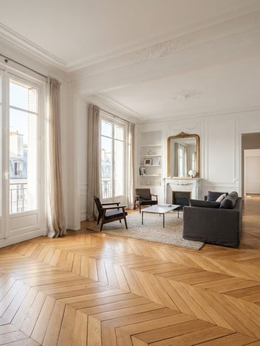 Immaculate Parisian apartment interior with perfectly laid oak parquet catching soft morning light, white walls, clean plaster moldings, wide architectural shot