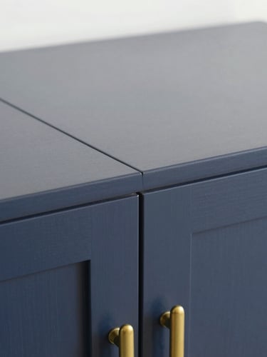 Detailed macro shot of a custom dark blue wooden cabinet joint, perfectly flush, matte finish, elegant brass hardware, natural side lighting