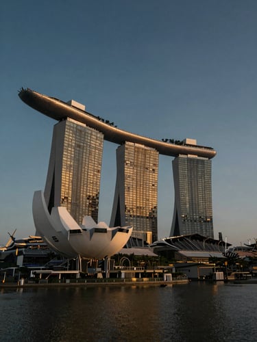 Wide environmental architectural shot of Singapore's Marina Bay financial district, low powerful angle, deep midnight shadows and warm golden hour highlights, avoiding harsh glare.