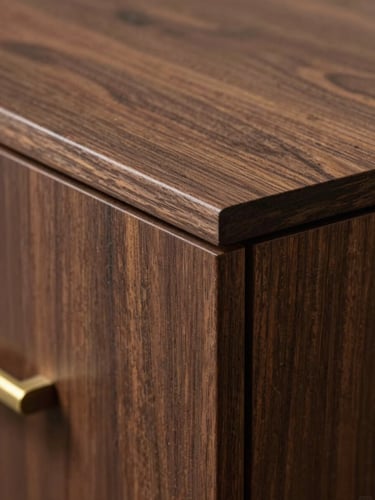 Close-up of architectural millwork joint on a dark walnut panel, precision-routed edge detail visible under raking north-facing daylight, bronze hardware partially in frame