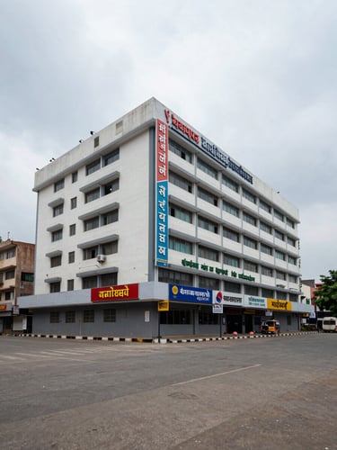 Ground-level wide shot of a Vadodara commercial district facade, overcast daylight, multi-storey office buildings with signage, empty forecourt showing scale and presence, no people or lifestyle staging