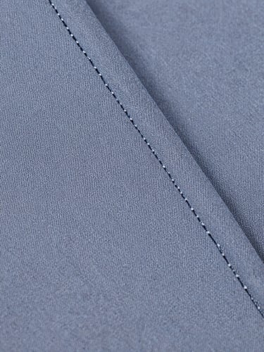 Extreme close-up of school uniform fabric — tight weave of a grey-blue cotton-poly blend, thread interlace fully visible, a reinforced seam running diagonally through the frame, shot under bright even studio light with no shadows, full detail across the surface