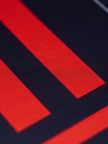 Extreme close-up of a digital interface with stark red geometric shapes and deep charcoal shadows, harsh directional studio lighting.