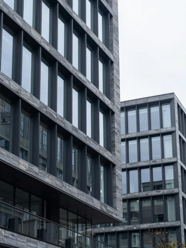Contemporary corporate architecture detail, clean geometric lines of glass and steel, cool diffused daylight, slate gray tones, sharp focus.