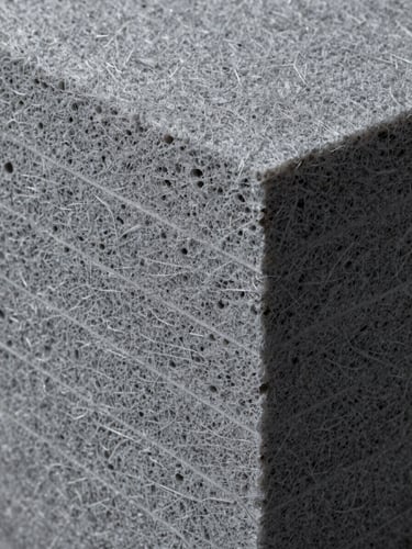 Extreme close-up cross-section of layered mineral wool insulation board, cool north-facing studio light revealing dense fibrous texture and precise cut edges, gray tones, no people