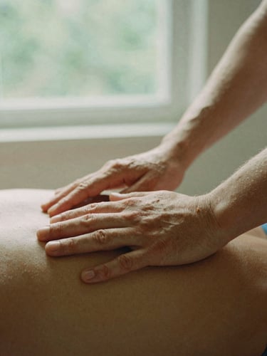 Close-up of hands gently assisting a patient during physical therapy, warm morning daylight filtering through a window, soft green tones, 35mm