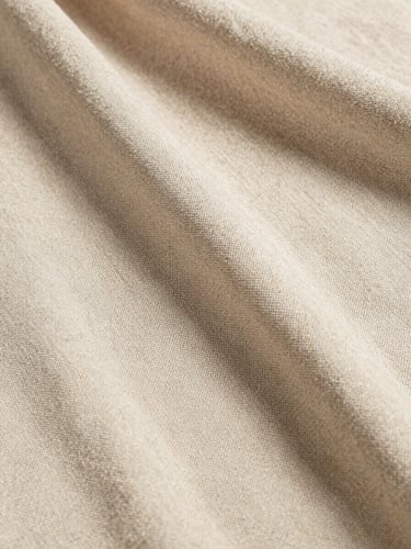 Extreme portrait-oriented close-up of heavy linen fabric swatch in champagne beige, soft natural daylight casting gentle shadows, showing detailed weave and texture