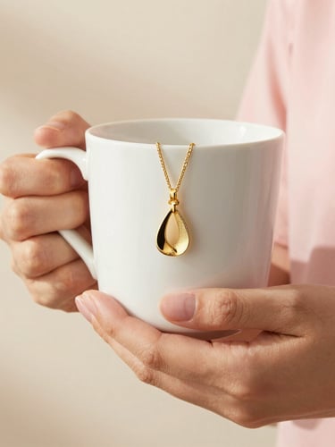 Close-up of hands holding an elegant ceramic mug and styling gold jewelry, warm morning light, pale pink and cream background, 35mm