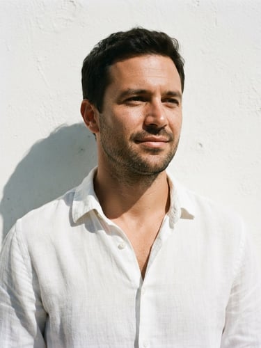 Medium-close crop of a man in a relaxed white linen shirt, direct sunlight, sharp shadows, minimalist white wall background, 35mm film