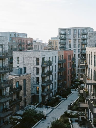Editorial architectural photography, crisp overcast daylight, high-angle shot of a modern London residential development with clean brickwork and geometric balconies, 35mm