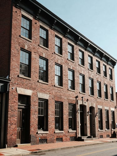 Wide-angle architectural perspective of a restored brick business district in North Carolina, sharp morning sunlight, clean geometric lines, high contrast.