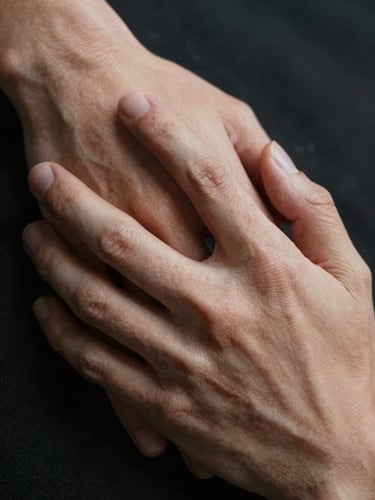 Extreme close-up of two hands gently intertwined, soft dramatic lighting from the side, focus on skin texture and fabric