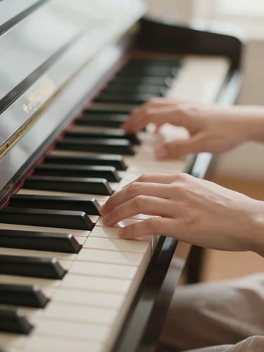 Close-up of gentle hands resting on piano keys under soft diffused natural daylight, warm calming atmosphere, shallow depth of field