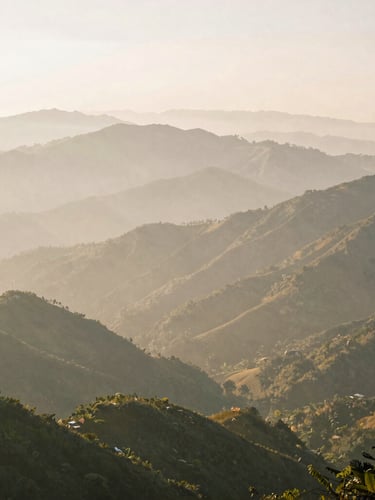 Wide panoramic view of misty mountain ranges in northern Vietnam at sunrise, deep perspective, soft morning light, 35mm film style.