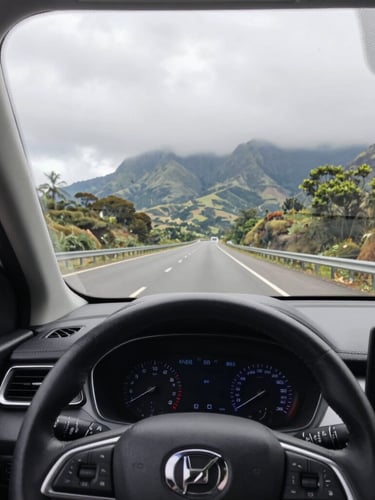 First-person driver perspective from a clean modern sedan dashboard looking out onto a scenic highway toward the Western Ghats, bright overcast daylight