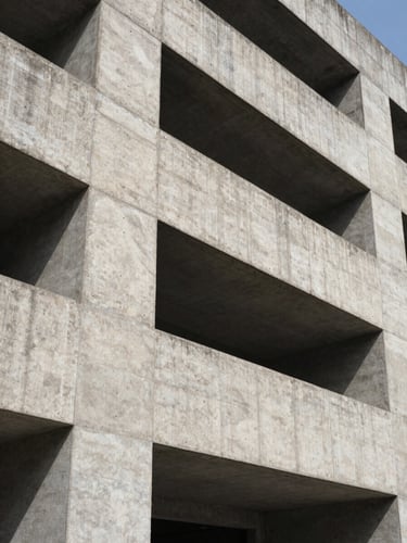Low-angle heroic shot of a brutalist concrete building facade, raw texture, sharp geometric shadows, bright daylight
