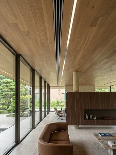 Interior de residência de alto padrão com sistema de climatização linear embutido no teto de madeira