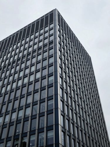 Low-angle architectural detail of a modern European financial headquarters, cool overcast daylight, desaturated navy tones, 35mm