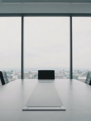 An empty high-end boardroom interior in Budapest, minimalist design, cool overcast daylight filtering through large windows, desaturated tones, 35mm