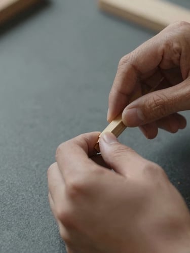 Close-up of hands carefully carving wood or engaging in a precise craft, soft indirect daylight, muted earth tones and slate, sharp focus, 35mm