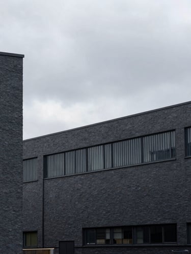 Stark architectural lines of Manchester industrial park buildings under overcast grey skies, high contrast, 35mm lens, sharp focus, industrial editorial style.