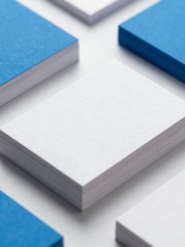 Clean close-up of premium business cards stacked neatly on a minimalist desk, showing crisp embossed textures and sharp edges under bright studio light with vibrant blue accents